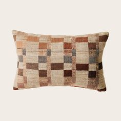 a brown and tan patchwork pillow on a white background