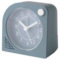 a small blue clock with white hands and numbers on the face, sitting in front of a white background