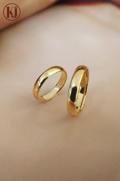 two gold rings sitting on top of a table