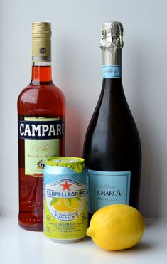 three bottles of wine, two lemons and a can of campari