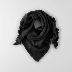 a dark colored scarf with fringes on the ends is laying on a white surface