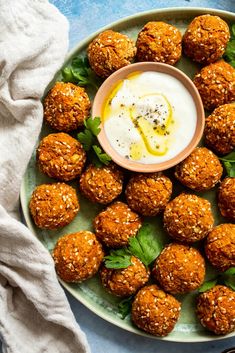 a plate filled with meatballs and dipping sauce on top of it next to a bowl of ranch dressing