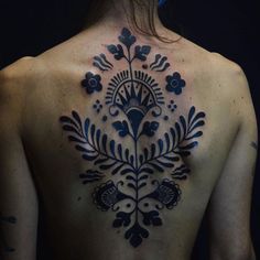 the back of a woman's body with tattoos on it