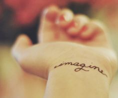 the word imagine written in cursive writing on someone's arm and foot