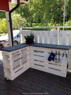 an outdoor kitchen made out of pallets and wooden planks with gardening utensils on the counter