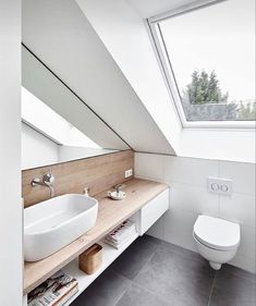 a white toilet sitting next to a bathroom sink under a skylight in a bathroom