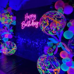 neon lights and balloons are lit up for a birthday party with the words happy birthday on it