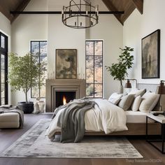 a large bedroom with a fireplace and lots of windows