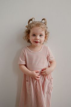 Let her twirl to her heart's content in this playful little Myra dress, reminiscent of sugar and all things sweet! Designed for maximum comfort and practicality, this classic striped dress with adorable front pockets will become a summer staple in her closet. Fit: runs a little small, so check the size chart and size up if in doubt Style: pull on knit dress in classic pink and white stripes with front pockets Color: pink and white Fabric content: 35% Rayon 60% Polyester 5% Spandex Care instructions: wash gentle cycle, cold; lay flat to dry, cool iron if needed. For best results, always follow care instructions on garment label. Our sizing is always approximate and can vary due to personal preference and style. For the best experience - and to make life easier for everyone! - please careful Cute Striped Cotton Dress, Striped Summer Dress For Playtime, Striped Spring Dresses For Playtime, Cute Striped Dress For Playtime, Striped Summer Dresses For Playdate, Striped Dresses For Summer Playdate, Playful Striped Short Sleeve Dress, Striped Short Sleeve Dresses With Pockets, Playful Striped Dresses For Playdate