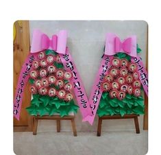 two pink and green decorated chairs sitting on top of a floor next to each other