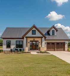 a large house with a metal roof and two car garages