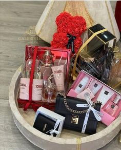 a basket filled with lots of different types of perfumes and handbags on top of a table