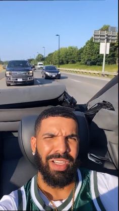 a man with a beard sitting in the passenger seat of a car looking at the camera