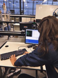 a woman sitting at a desk using a computer