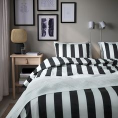 black and white striped bedding with pictures on the wall