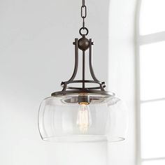 a light fixture hanging from the ceiling in a room with white walls and window sill