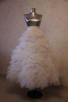 a white wedding dress on display in front of a wall