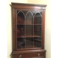 a wooden cabinet with glass doors in a room