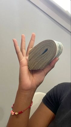 a person holding up a roll of paper in the air with their hand on top of it