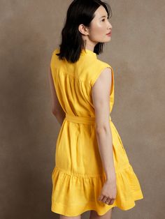 Beloved for its freeing shape, this lightweight linen mini dress is cut with shirred shoulders, a flounced hem, and utility-inspired topstitch details that add soft structure to its feminine form.  SWING FIT: Cut for a flowing, A-line fit.  No waist Yellow Umbrella, Flounce Dress, Linen Shirt Dress, Linen Mini Dress, Flounced Dress, Dress Yellow, Band Collar, Yellow Dress, Linen Shirt