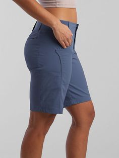 a woman in blue shorts is standing with her hands on her hips and looking down