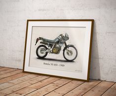 a framed photograph of a motorcycle on a wooden floor