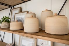 some pots are sitting on top of a shelf