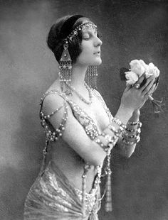 an old fashion photo of a woman holding flowers in her right hand and looking up at the sky