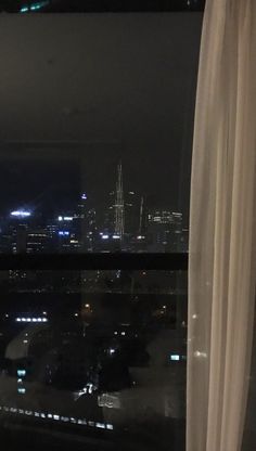 the city lights are lit up in the distance from this window sill at night