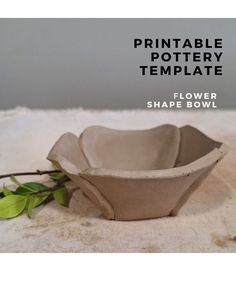 a paper bowl sitting on top of a table next to a twigy plant