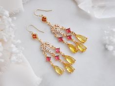 Make a statement this summer with these colorful earrings created with 14k gold filled earrings for a comfortable all day wear! Suspended from the statement earrings are yellow teardrops accented with princess cut magenta pink faceted glass and tiny cubic zirconia charms in a floral design. Whether searching for chandelier earrings earrings for a whimsical wedding or a unique birthday gift for a best friend, all of my jewelry arrives suitably gift wrapped ready for gift giving. Measurements: The Elegant Multicolor Chandelier Earrings For Celebration, Yellow Dangle Chandelier Earrings For Party, Yellow Teardrop Earrings For Wedding, Elegant Multicolor Drop Bridal Earrings, Yellow Drop Earrings For Celebration, Yellow Dangle Chandelier Earrings For Wedding, Multicolor Dangle Bridal Earrings, Multicolor Dangle Bridal Earrings For Pierced Ears, Yellow Ear Wire Earrings For Wedding