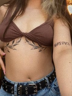 a woman with a tattoo on her stomach and the words divine written in cursive writing