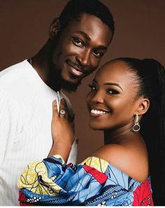 a man and woman are posing for a photo with their arms around each other, both smiling at the camera