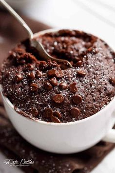 a spoon in a bowl filled with chocolate cake