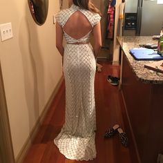 a woman in a white dress looking at herself in the mirror