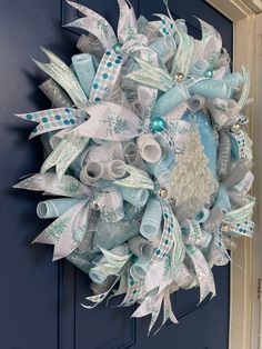 a blue and white christmas wreath hanging on the front door