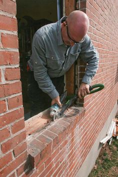 a man is working on a brick wall