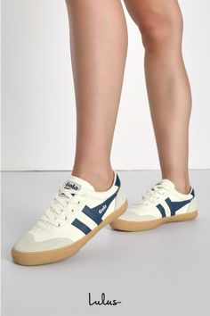 We're ready to hit the town (and court) in the GOLA Badminton Off White and Baltic Color Block Suede Sneakers! Sturdy woven canvas and genuine suede leather come together in hues of white, light grey, and dark blue, to form a rounded toe and a classic lace-up vamp. Low-cut collar, with logo tag at the tongue and outstep, completes the retro-style look! 1. 15" rubber heel. Lightly cushioned insole. Rubber sole has nonskid markings. Upper: Textile. Leather. Lining & Sock: Textile. Sole: Other Mate Sporty Suede Canvas Shoes With Rubber Sole, Sporty Leather Canvas Shoes With Gum Sole, Gola Badminton, Green Event, Lulu Fashion, Leather Accents, Logo Tag, Suede Sneakers, Rubber Heels