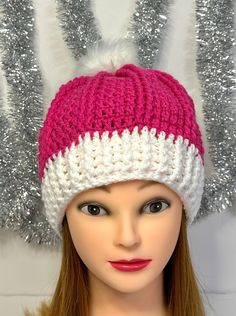 a mannequin head wearing a pink and white knitted hat