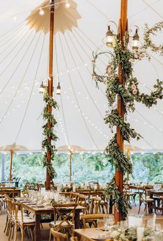 the inside of a tent with tables and chairs set up for an outdoor wedding reception