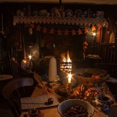 a table topped with lots of food next to a fire place filled with lit candles