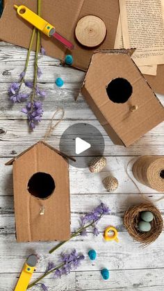 several birdhouses are sitting on the table with flowers and crafting supplies around them