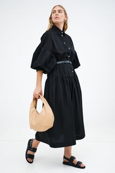 Meet our Ada Dress, the ultimate warm weather staple. She's a midi shirtdress handcrafted from 100% European poplin cotton, featuring pockets and a dropped gathered waistline that falls over your frame with ease. Her clean lines and sharp collar harmonize with dramatic dropped shoulders and full-bodied sleeves, elevating your style for any occasion.[SPLIT] Maritza, in black and in light blue, is 5'9.5" (177 cm) tall, wearing size XS. Shannon, in white, is 5'8" (173 cm) tall, wearing a size M. Mi Chic Billowy Midi Dress For Daywear, Chic Shirt Dress With Gathered Sleeves For Work, Modern Cotton Midi Dress, Spring Chic Shirt Dress With Gathered Sleeves, Chic Spring Shirt Dress With Gathered Sleeves, Fall Pleated Waist Shirt Dress For Daywear, Voluminous Skirt Midi Dress For Daywear, Voluminous Midi Dress For Spring Daywear, Chic Oversized Midi Shirt Dress