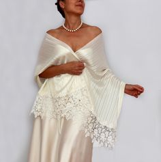 This elegant one-of-a-kind ivory bridal shawl is subtly enhanced with slight silver threading, adding a delicate shimmer to its design. Measuring 59.1" in length (150 cm, excluding the wide lace trims) and 21.7" (55 cm) in width, it drapes gracefully over the upper body. The combination of shimmery fine satin fabric and generous guipure lace trims makes it an ideal, refined accessory for any bride.  *It's suitable for those with an upper body circumference, including the chest and arms, up to 46.1" (117 cm).* **For reference, the model pictured is wearing a size S/M with a body circumference of 40.6" (103 cm).** For more similar wedding & evening cover-ups, please kindly visit https://www.etsy.com/shop/mammamiabridal?section_id=11494946 https://www.etsy.com/shop/mammamiaeme?section_id=1848 Elegant White Evening Veil, Fitted Shawl For Mother Of The Bride, Elegant White Evening Shawl, Elegant Cream Shawl For Evening, Cream Silk Shawl For Wedding, Cream Shawl For Evening, Cream Pashmina Shawl For Wedding, Elegant Silk Shawl For Weddings, Elegant Satin Shawl For Wedding