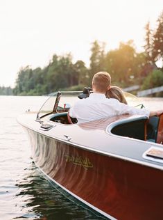 a man and woman are riding in a speedboat on the water with their backs to each other