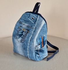 a backpack made out of old jeans with pencils in the pocket