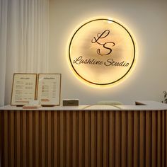 the front desk of a salon with a lighted sign above it