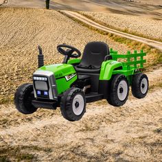 a green tractor parked on top of a dirt road