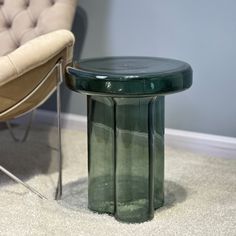 a green table sitting on top of a carpeted floor next to a chair