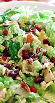 a salad with lettuce, cranberries and pecans on the side